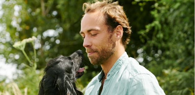 James Middleton looking down at one of his spaniels