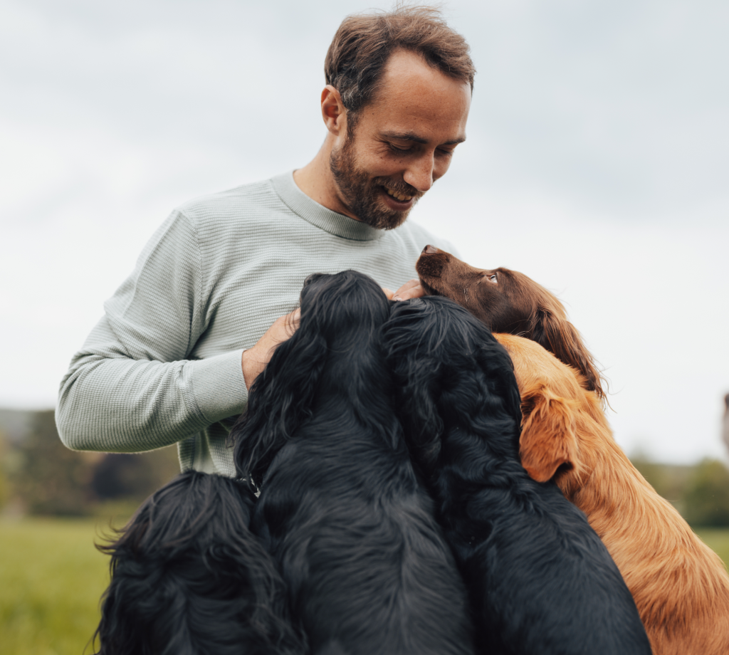 James Middleton smiling down at his dogs