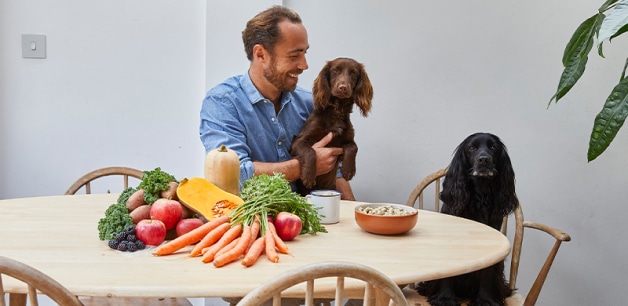 James middleton with two of his cocker spaniels, sat at a table with a display of healthy ingredients