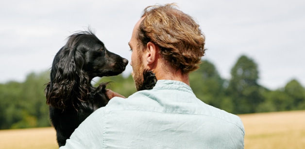 A view from behind of James middleton holding his dog Ella