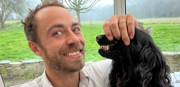 James middleton grinning next to his black cocker spaniel showing teeth