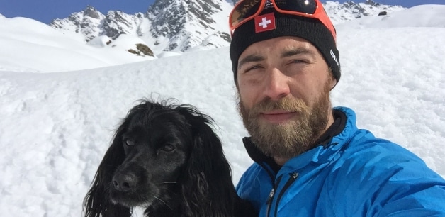 James Middleton and his black cocker spaniel Ella stand on a snowy mountain
