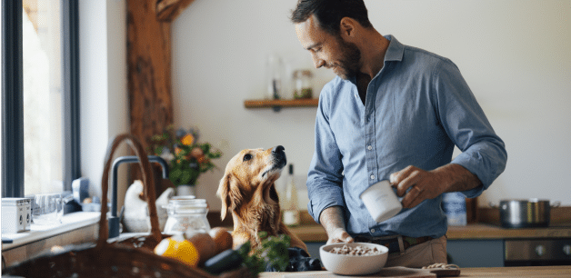 James middleton smiling down at golden retriever whilst holding bowl of freeze-dried food