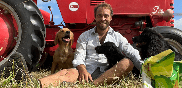 James middleton sat in front of tractor with dogs on hot day