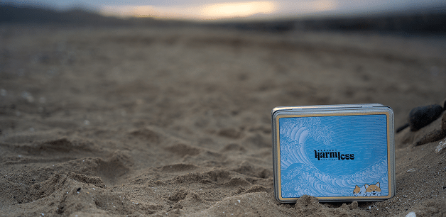 eco-friendly tin of Project harmless dog poo bags, on a sandy beach